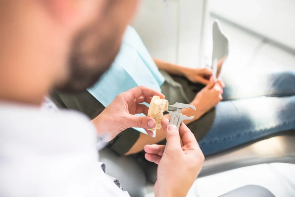 Dentista midiendo una dentadura de un paciente para poner una corona dental